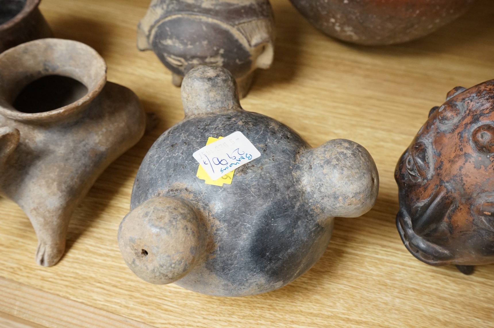 A collection of various South American vessels some in the form of grotesque heads, largest 24cm wide
